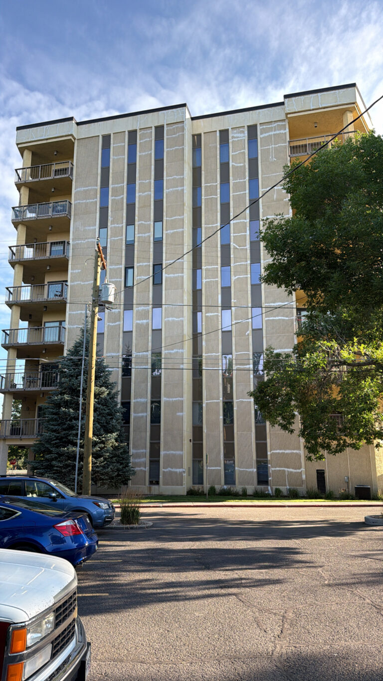 Window perimeter caulking and panel joint work in progress on a high-rise tower
