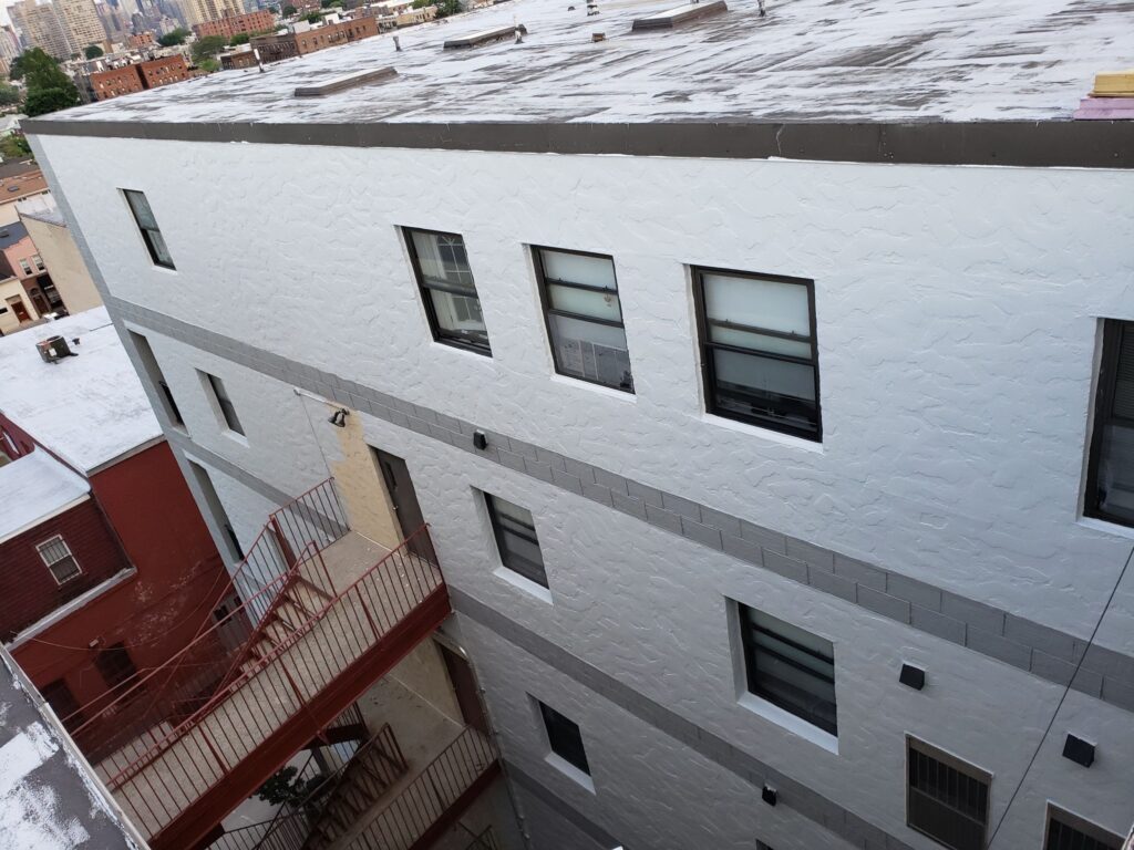 Stucco building wall after a new white and gray elastomeric coating