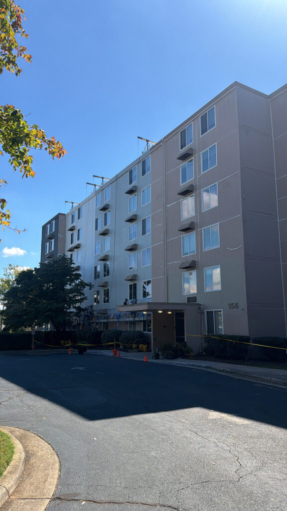 Mid-rise apartment building with a freshly painted gray and white exterior