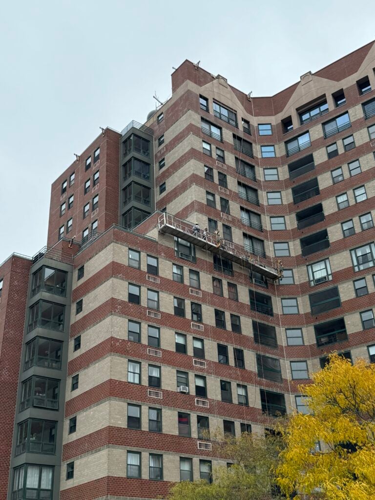Swing stage on a brick high-rise during façade restoration