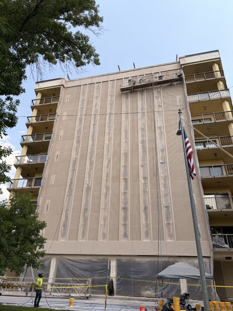 Vertical panel joints on a balcony tower during commercial caulking and coating work
