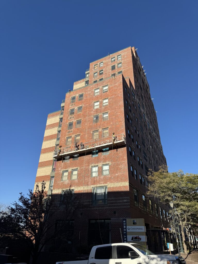 Swing stage high on a brick tower during masonry and façade work